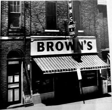 Brown's Drug Store on Front Street in Deposit, NY, with its striped awning and Drugs & Soda sign